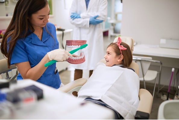 assistant showing teeth to girl